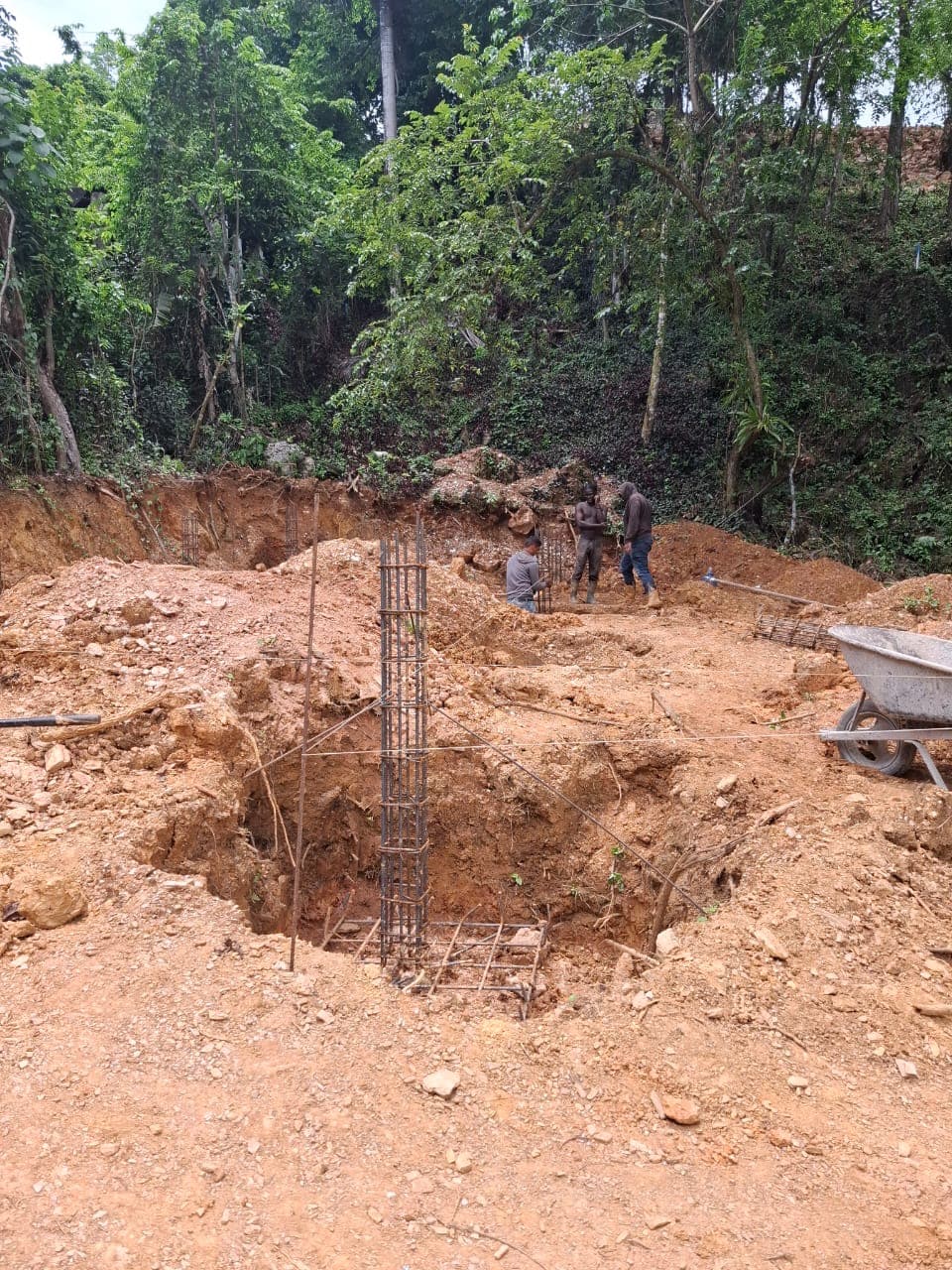 Workers excavating the first foundation, a steel column cage set into a dug footing